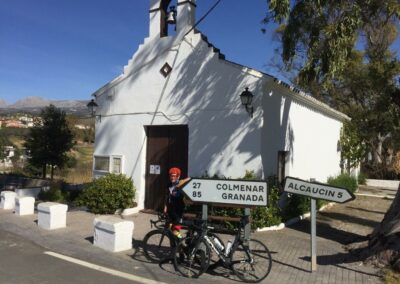 Cyclists in front of a white chapel